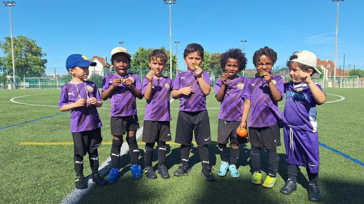 Jeunes joueurs de l'École de Football du HAC montrant leurs médailles